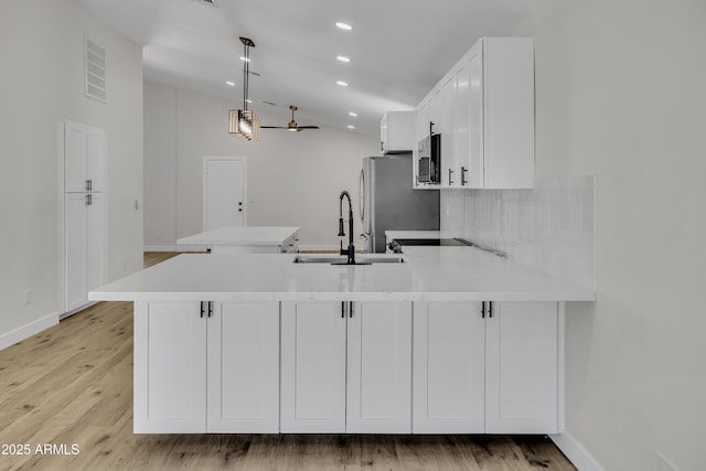 3926 E Coconino St, Phoenix, AZ 85044 - kitchen featuring a peninsula, stainless steel appliances, decorative backsplash, light countertops, and white cabinetry