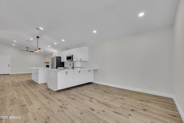 3926 E Coconino St, Phoenix, AZ 85044 - kitchen with appliances with stainless steel finishes, a peninsula, light countertops, white cabinetry, and light wood-style floors