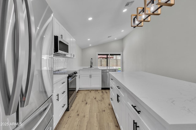 3926 E Coconino St, Phoenix, AZ 85044 - kitchen with appliances with stainless steel finishes, recessed lighting, light wood-style floors, lofted ceiling, and backsplash