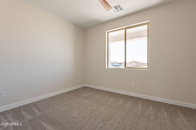 carpeted spare room featuring visible vents and baseboards