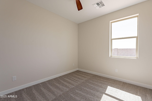 carpeted spare room featuring a ceiling fan, visible vents, and baseboards