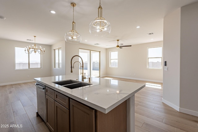 kitchen featuring dishwasher, visible vents, light wood finished floors, and a sink