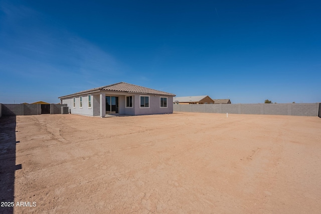 back of house featuring a tile roof and a fenced backyard