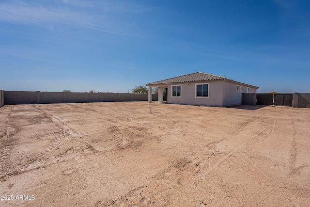 exterior space with a tile roof, fence, and stucco siding