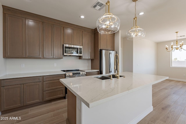 kitchen featuring light wood-type flooring, visible vents, appliances with stainless steel finishes, and a sink