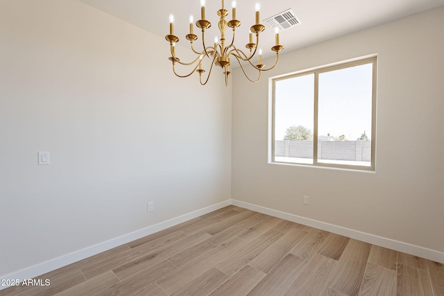 unfurnished room featuring light wood-style flooring, visible vents, and baseboards