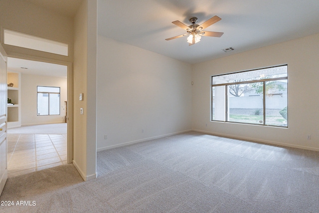 carpeted spare room with ceiling fan