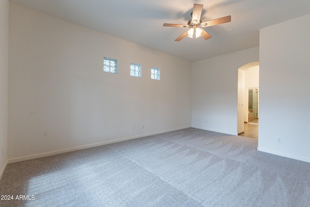 2223 E Branham Ln, Phoenix, AZ 85042 - empty room with ceiling fan, baseboards, arched walkways, and light colored carpet