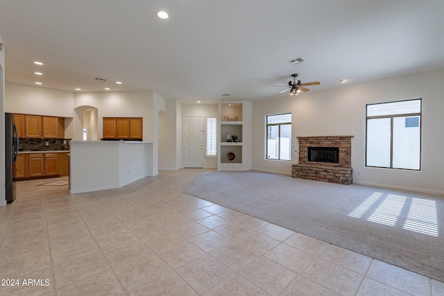 unfurnished living room with light colored carpet and ceiling fan