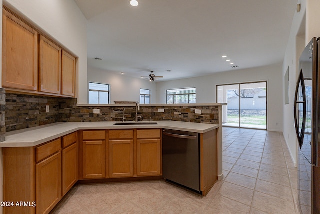 kitchen with sink, kitchen peninsula, backsplash, dishwasher, and black refrigerator