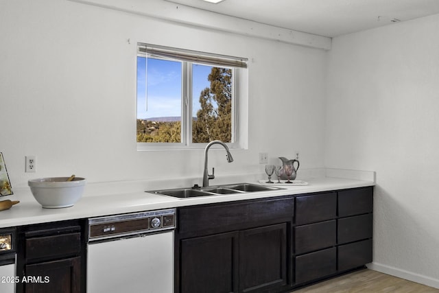 kitchen featuring dishwasher, sink, and light hardwood / wood-style floors