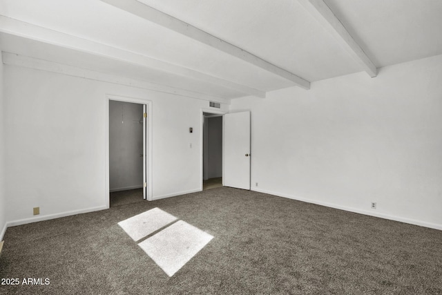 unfurnished room with beamed ceiling and dark colored carpet