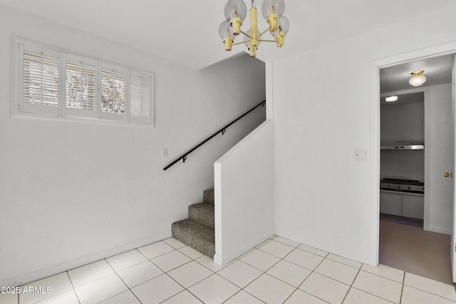 stairs featuring tile patterned floors and an inviting chandelier