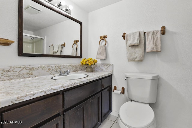 bathroom featuring tile patterned flooring, vanity, an enclosed shower, and toilet