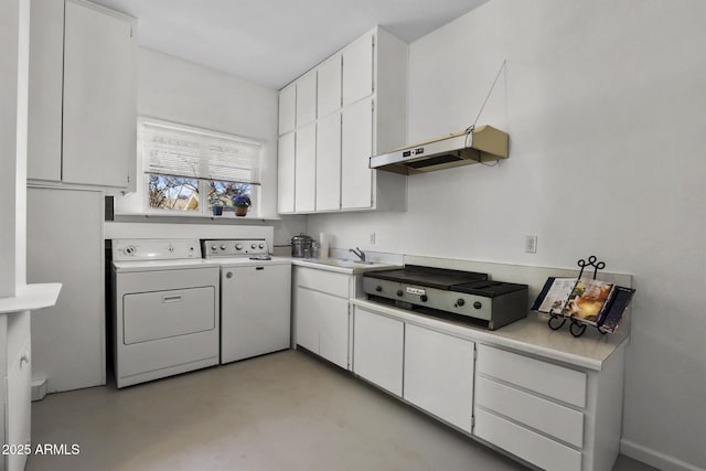 kitchen featuring white cabinetry, sink, and washing machine and clothes dryer