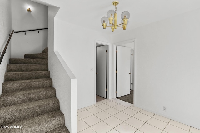 stairs with tile patterned flooring and an inviting chandelier