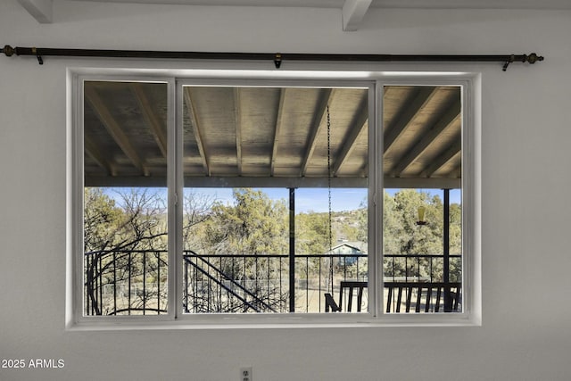 unfurnished sunroom featuring beam ceiling and a wealth of natural light