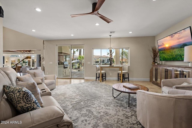 living room featuring ceiling fan with notable chandelier