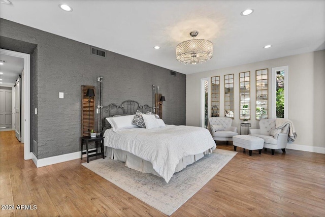 bedroom featuring light hardwood / wood-style flooring and a chandelier