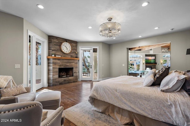 bedroom with a notable chandelier, hardwood / wood-style flooring, access to outside, and a fireplace