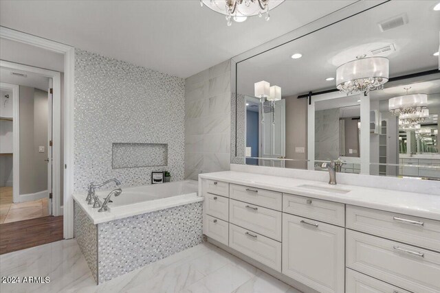 bathroom featuring vanity and a relaxing tiled tub