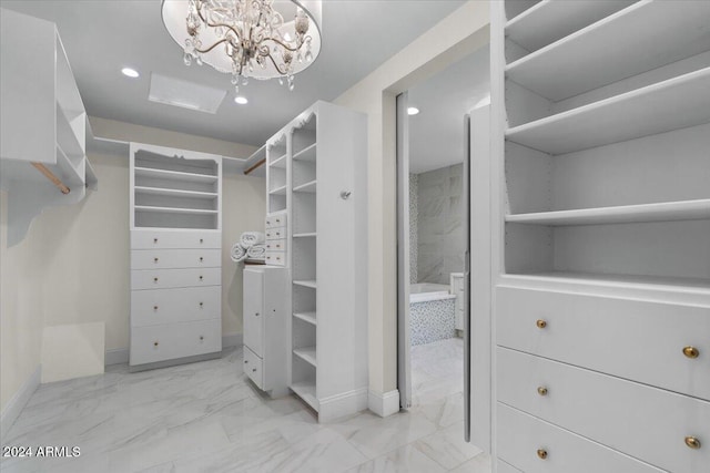 spacious closet with a chandelier