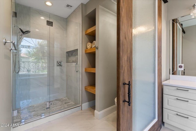 bathroom with a shower with door, vanity, toilet, and tile patterned flooring