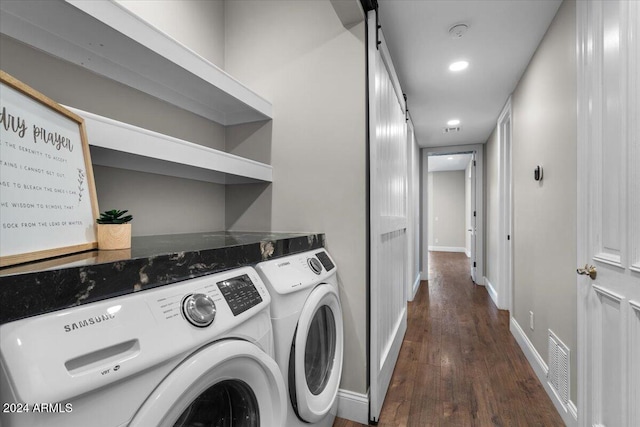 clothes washing area with washer and clothes dryer and dark hardwood / wood-style floors