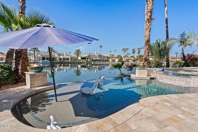 view of pool featuring a patio area, an in ground hot tub, and a water view