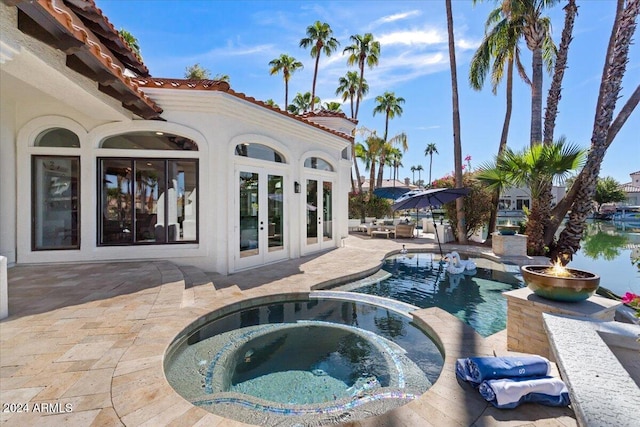 view of pool featuring an in ground hot tub, a patio area, and french doors