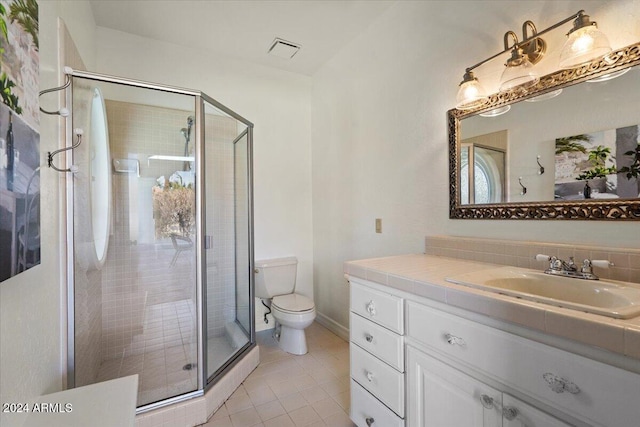 bathroom featuring toilet, an enclosed shower, vanity, and tile patterned floors