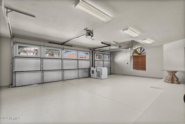 garage with a garage door opener and separate washer and dryer