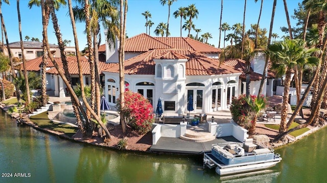 rear view of house with a water view and a patio