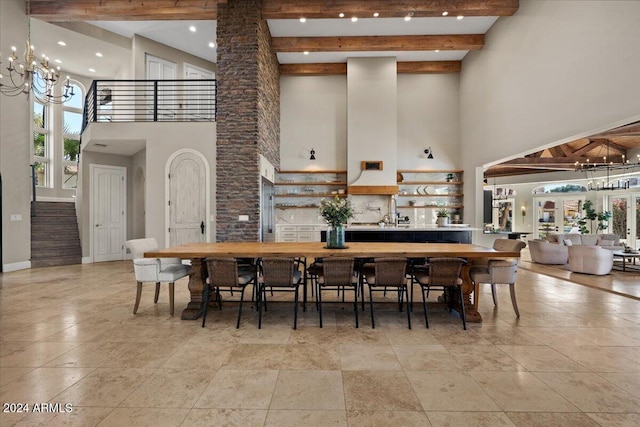 dining space with a towering ceiling, beamed ceiling, and ornate columns