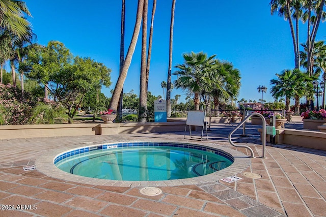 view of swimming pool with a patio area and a community hot tub