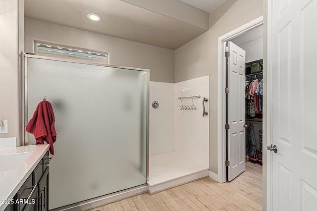 bathroom featuring vanity, wood-type flooring, and walk in shower