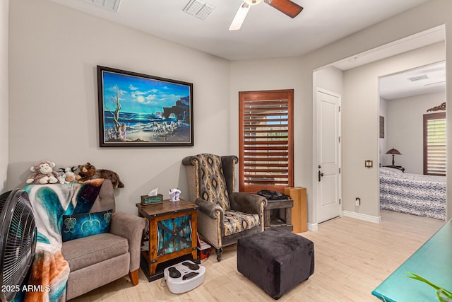 living area with ceiling fan and light hardwood / wood-style flooring