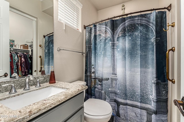 bathroom featuring vanity, toilet, and walk in shower