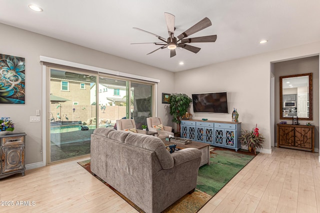 living room with ceiling fan and light hardwood / wood-style flooring