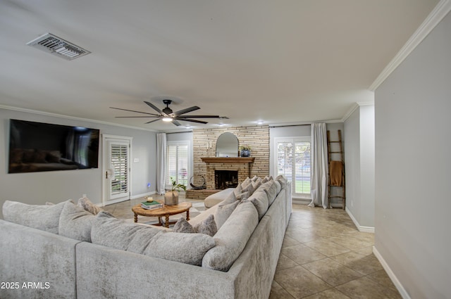 living room with ceiling fan, light tile patterned floors, ornamental molding, and a brick fireplace