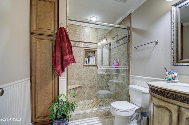 bathroom featuring tile patterned floors, vanity, a shower with door, crown molding, and toilet