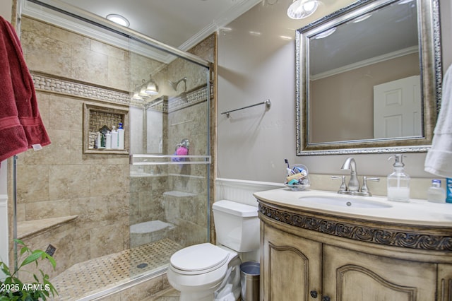 bathroom featuring a shower with shower door, toilet, ornamental molding, and vanity