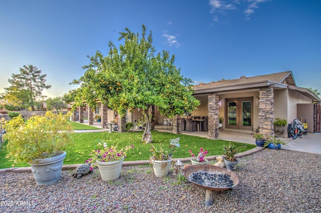 back of property with a yard, exterior bar, french doors, and a patio