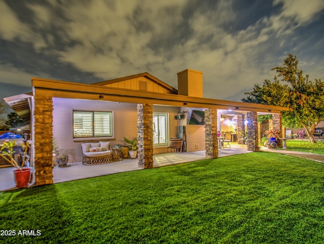 rear view of house with outdoor lounge area, a patio area, and a yard