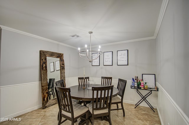 tiled dining room featuring ornamental molding and an inviting chandelier