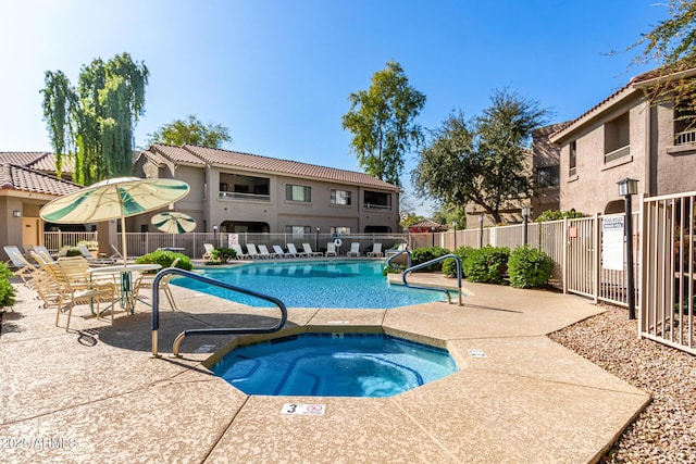 view of swimming pool featuring a hot tub