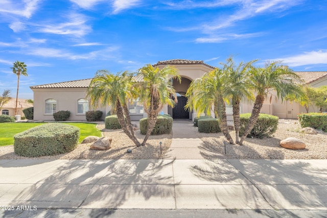 mediterranean / spanish-style house featuring a tiled roof and stucco siding