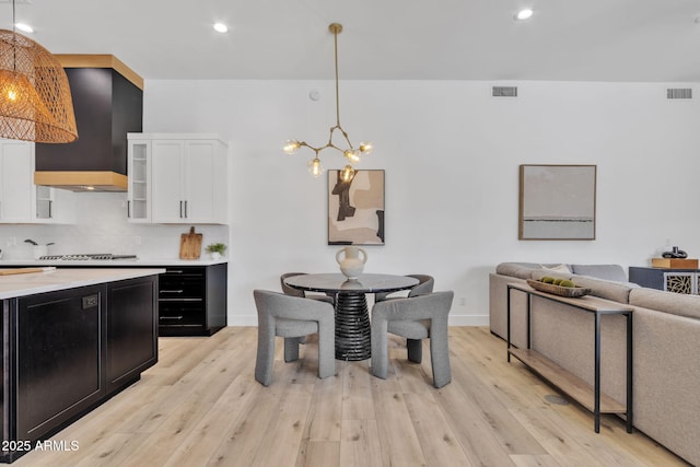 kitchen with a chandelier, dark cabinetry, visible vents, and white cabinetry