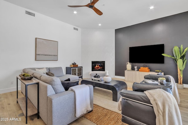 living room featuring recessed lighting, visible vents, a ceiling fan, light wood-type flooring, and baseboards