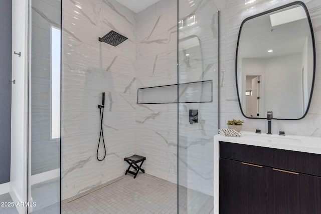 bathroom with vanity and a marble finish shower